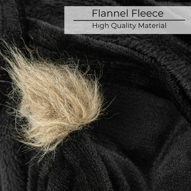 A black blanket with fur pom poms