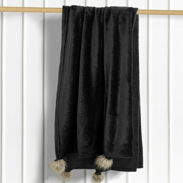 Black fur pom pom throw blanket, perfect for adding a touch of luxury to your home.