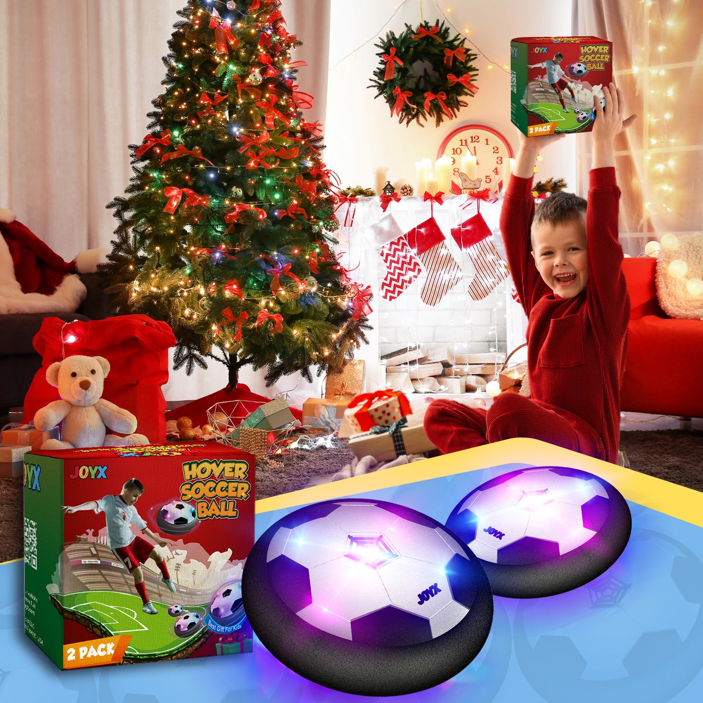 Excited child holding JOYX Hover Soccer Ball 2-Pack with illuminated Christmas tree and decorations in the background.